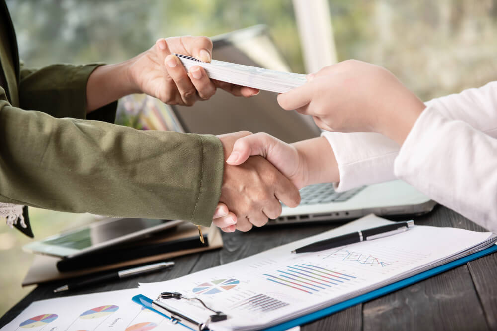 Handshake and document exchange representing instant loan approval and fast financial agreement